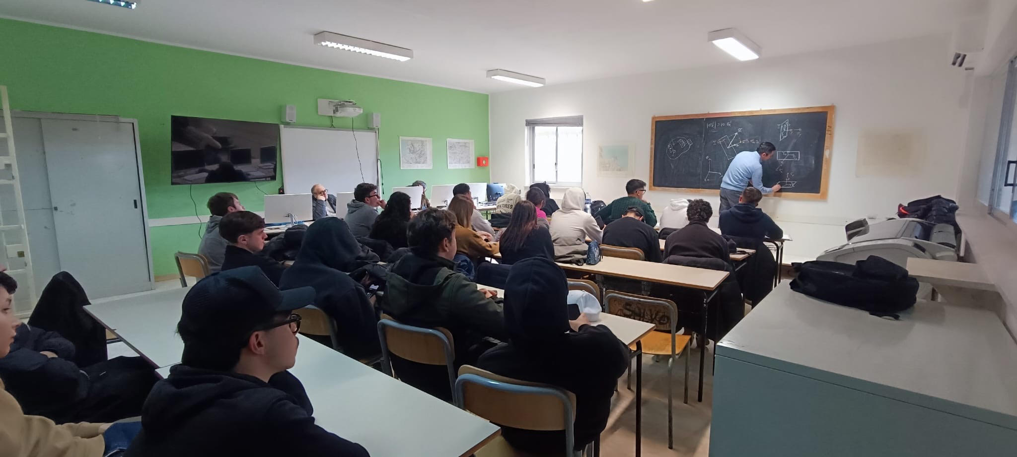 Una lezione di fisica delle costruzioni al CAT: il docente scrive alla lavagna e gli studenti seguono dai banchi
