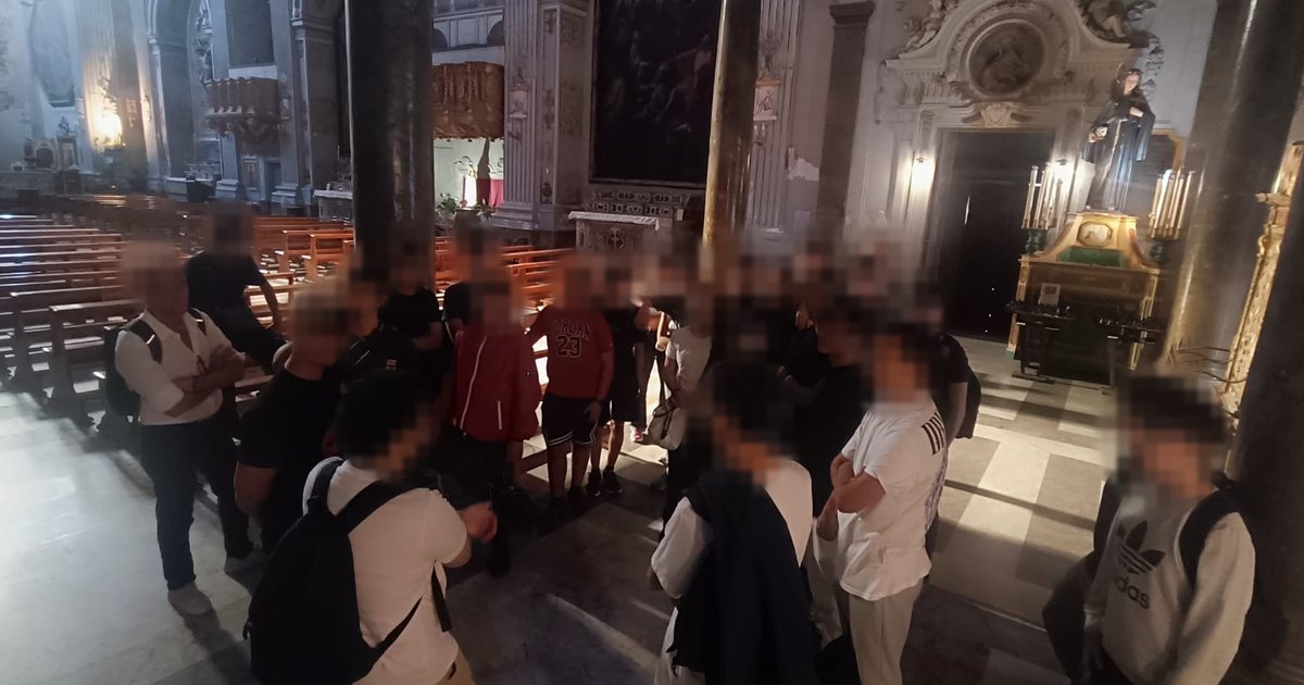 Un gruppo di studenti in cerchio nella navata di una chiesa durante un'uscita del progetto; i volti sono sfocati